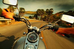 Driver riding motorcycle on an asphalt road in a tropics