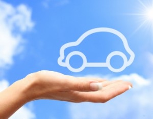 Hand with car against blue sky background